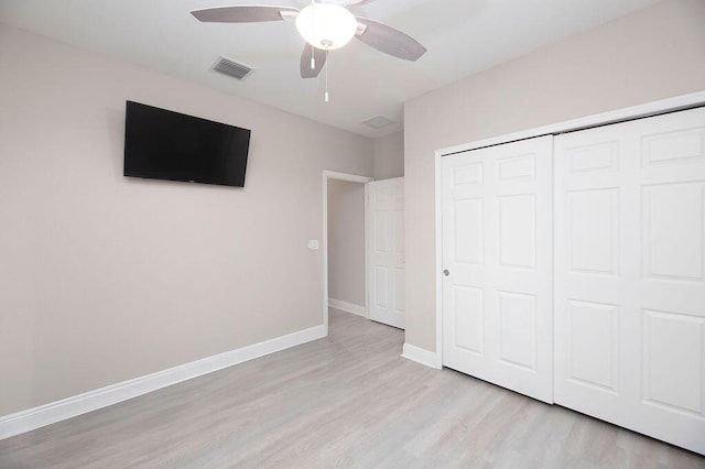 unfurnished bedroom with ceiling fan, light wood-type flooring, and a closet