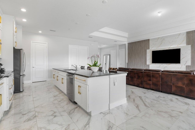 kitchen featuring sink, white cabinets, ornamental molding, a kitchen island with sink, and stainless steel appliances