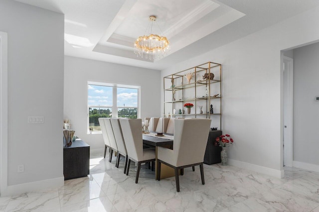 dining area featuring an inviting chandelier, a tray ceiling, and ornamental molding