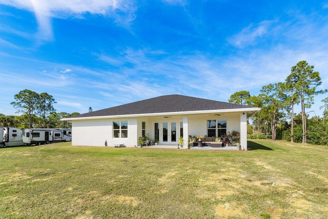 back of property featuring french doors, ceiling fan, a yard, and an outdoor hangout area