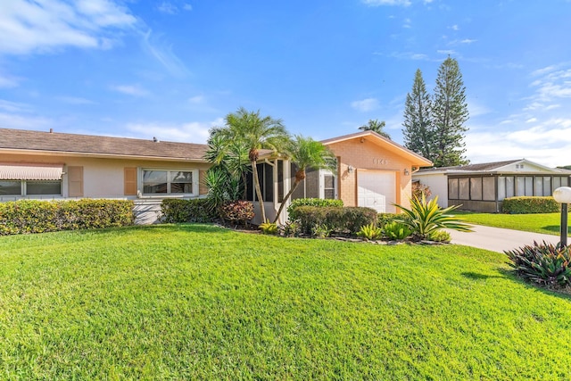 single story home featuring a garage and a front lawn