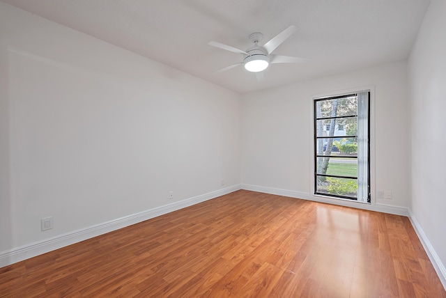 spare room featuring light wood-type flooring, ceiling fan, and baseboards