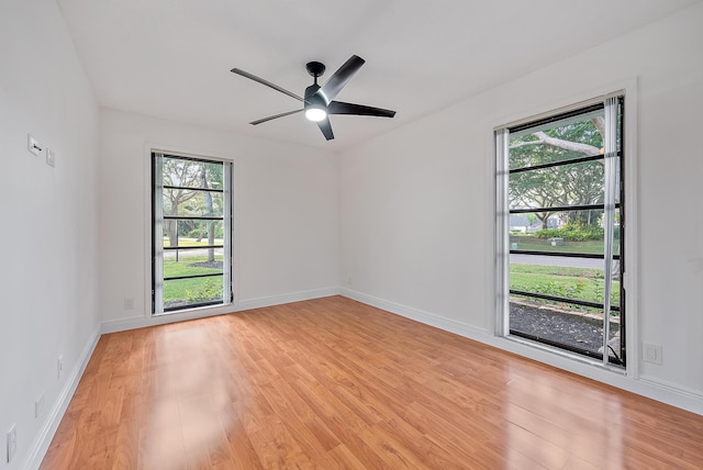 unfurnished room with plenty of natural light, light wood-style flooring, and baseboards