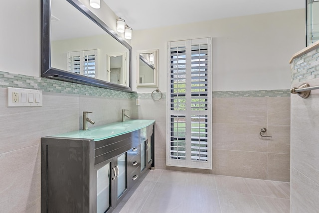 full bathroom with a sink, tile walls, and double vanity