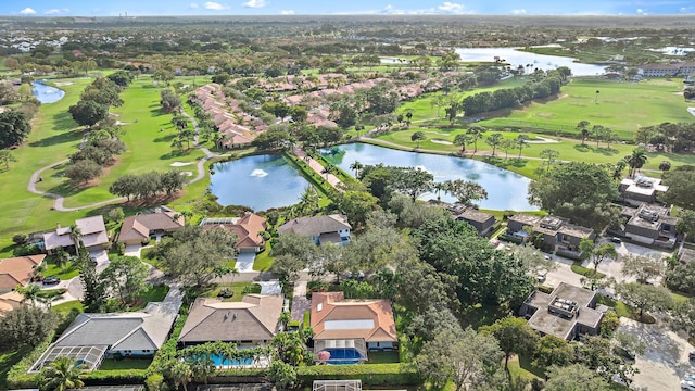 drone / aerial view featuring a residential view, view of golf course, and a water view