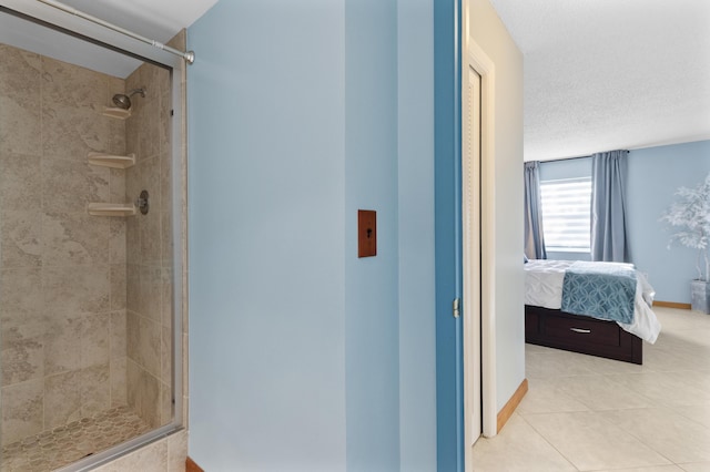 bathroom with tile patterned flooring, an enclosed shower, and a textured ceiling