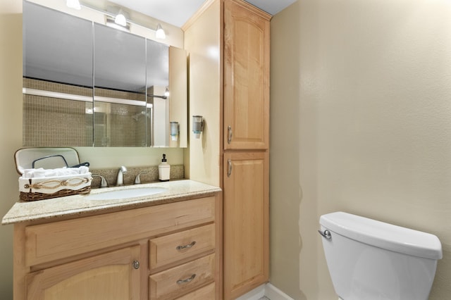 bathroom featuring vanity, a shower with shower door, and toilet