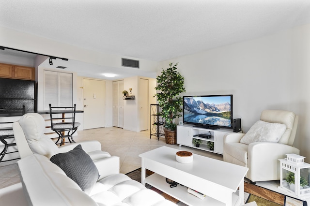 living room featuring a textured ceiling and light tile patterned floors