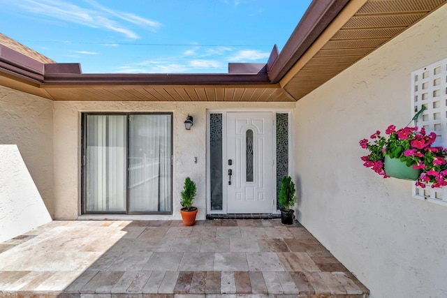 entrance to property with a patio area and stucco siding