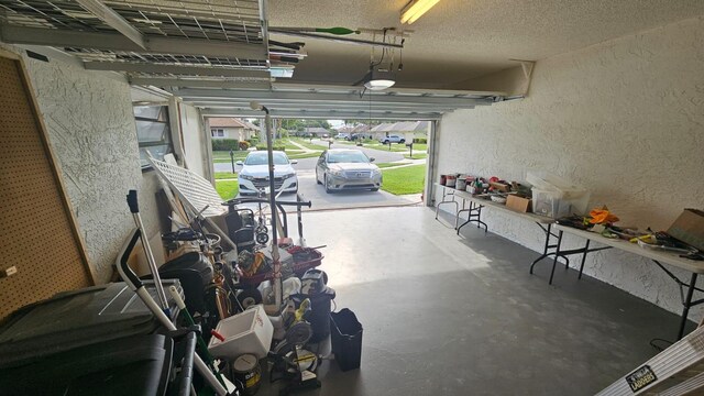 10298 Greentrail Dr N, Boynton Beach, FL 33436 - garage with a textured wall, a garage door opener, and covered porch