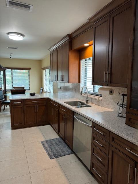 kitchen with visible vents, a peninsula, light countertops, stainless steel dishwasher, and a sink