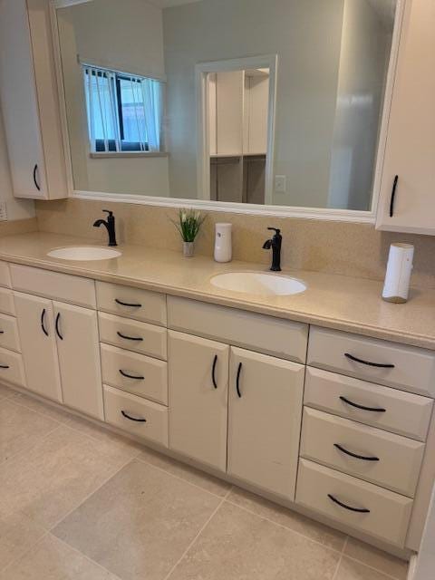 full bathroom with double vanity, tile patterned flooring, backsplash, and a sink