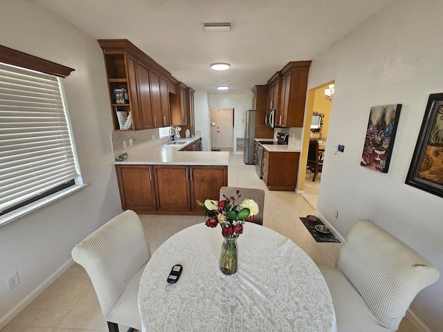 10298 Greentrail Dr N, Boynton Beach, FL 33436 - kitchen with a sink, stainless steel appliances, light tile patterned floors, open shelves, and decorative backsplash