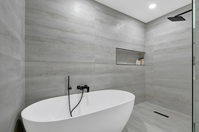 full bathroom with a freestanding tub, tiled shower, and recessed lighting