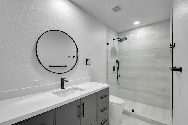 bathroom featuring visible vents, a textured wall, toilet, a shower stall, and vanity