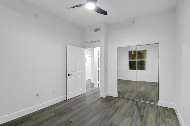 unfurnished bedroom with a closet, wood finished floors, visible vents, and baseboards