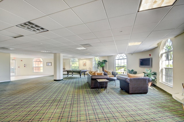 carpeted living area featuring a drop ceiling, plenty of natural light, and visible vents