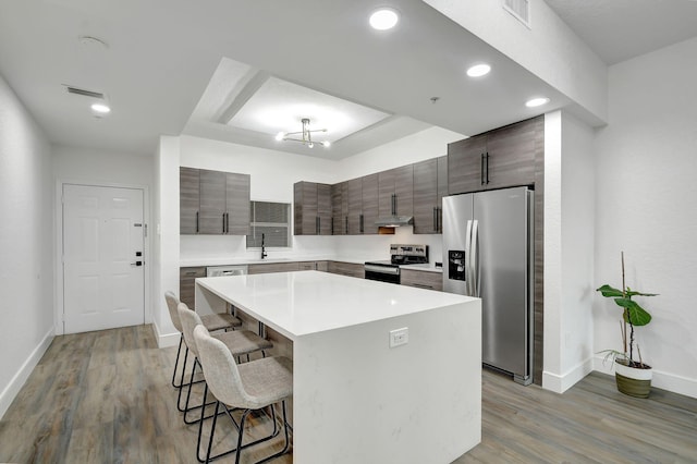 kitchen with a breakfast bar, visible vents, stainless steel appliances, and a sink