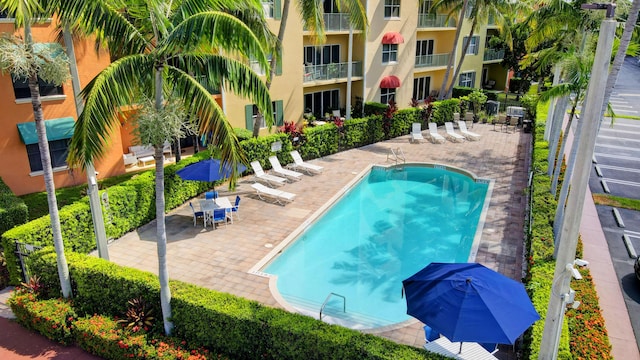 community pool with a patio and fence