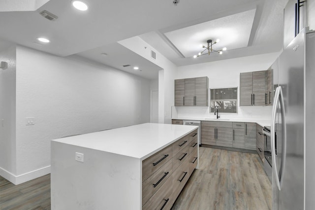 kitchen featuring light wood-style flooring, modern cabinets, stainless steel appliances, and a sink