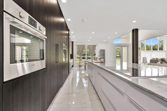 kitchen with white cabinetry, black electric stovetop, dark brown cabinets, and stainless steel oven