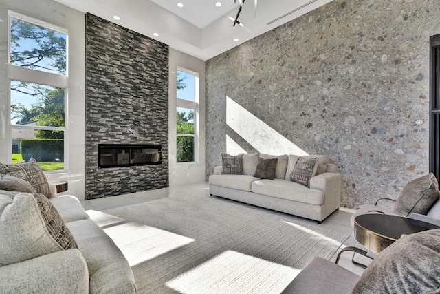 living room featuring a high ceiling, a wealth of natural light, and a fireplace