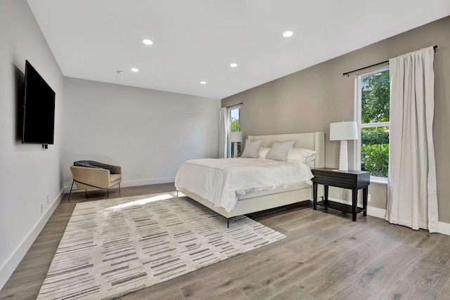 bedroom with multiple windows and light wood-type flooring