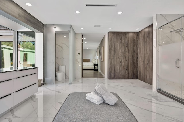 bathroom with a shower with door, vanity, and toilet