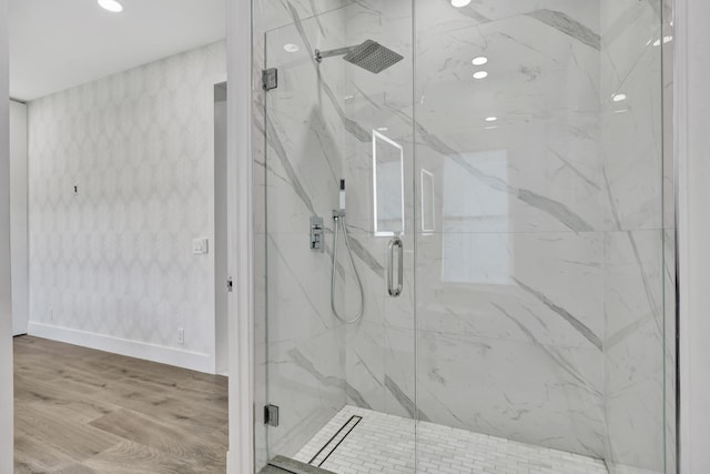 bathroom with hardwood / wood-style flooring and a shower with shower door