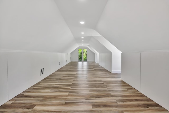 bonus room with vaulted ceiling and light hardwood / wood-style flooring