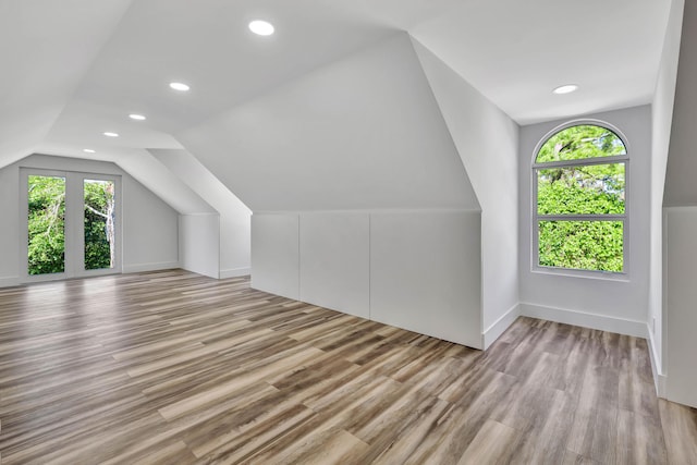 bonus room featuring vaulted ceiling and light wood-type flooring