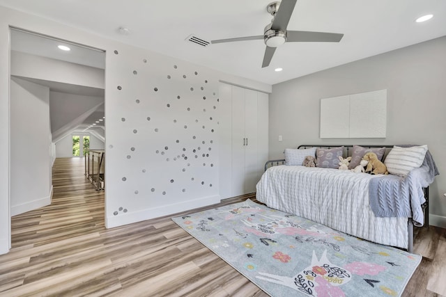 bedroom with ceiling fan, light hardwood / wood-style floors, and a closet