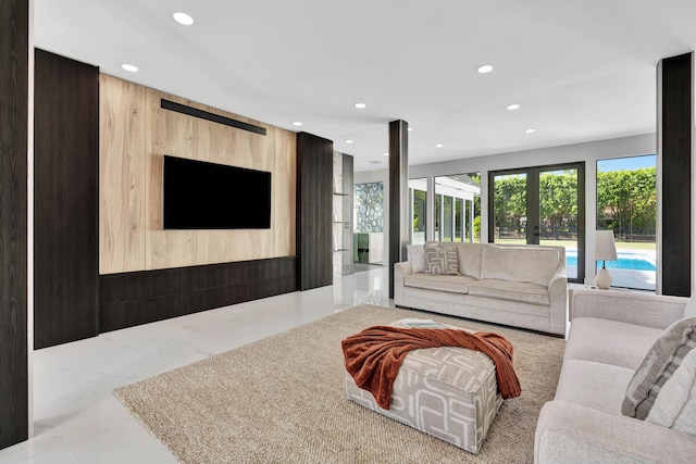 living room with french doors and wood walls