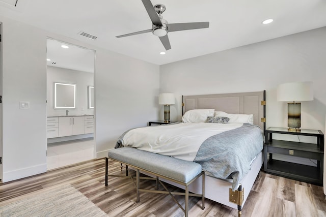 bedroom with ceiling fan, connected bathroom, and hardwood / wood-style floors