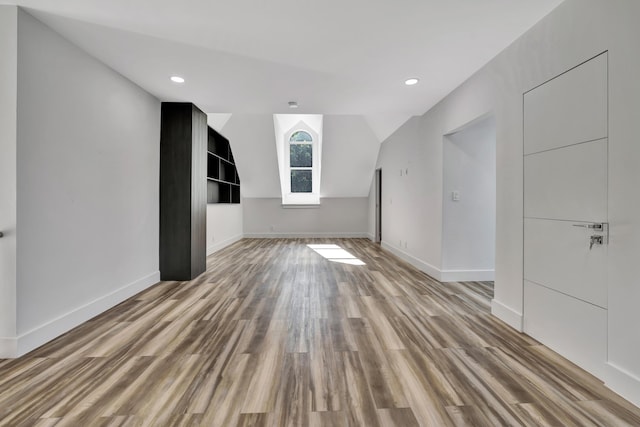 bonus room featuring lofted ceiling and light wood-type flooring