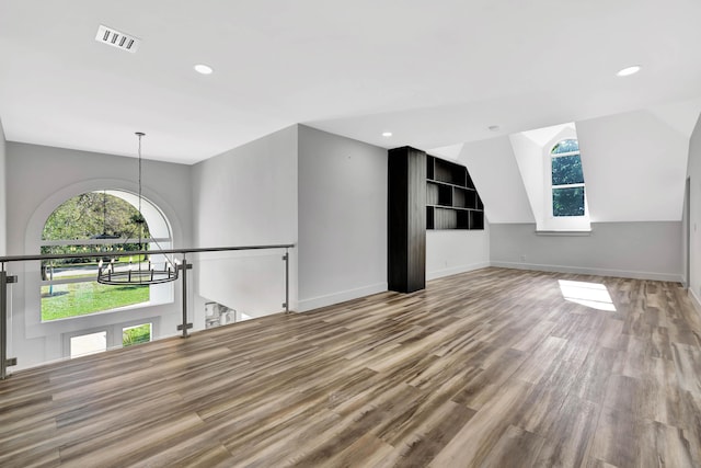 interior space with hardwood / wood-style flooring, lofted ceiling, and an inviting chandelier