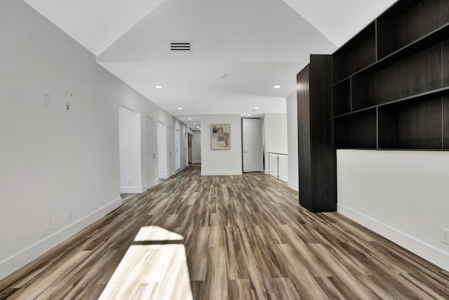 unfurnished living room with hardwood / wood-style flooring and vaulted ceiling