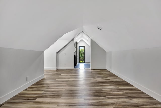 bonus room with wood-type flooring and vaulted ceiling