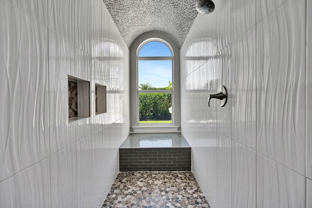 bathroom with walk in shower and lofted ceiling