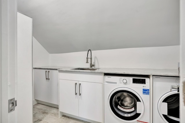 washroom with cabinets, sink, and washer and clothes dryer