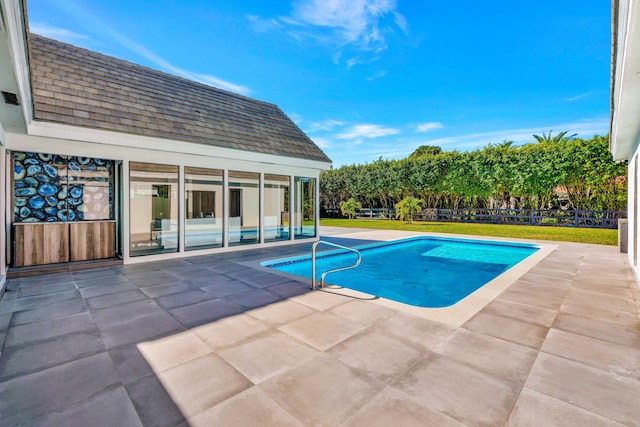 view of swimming pool featuring an outbuilding and a patio