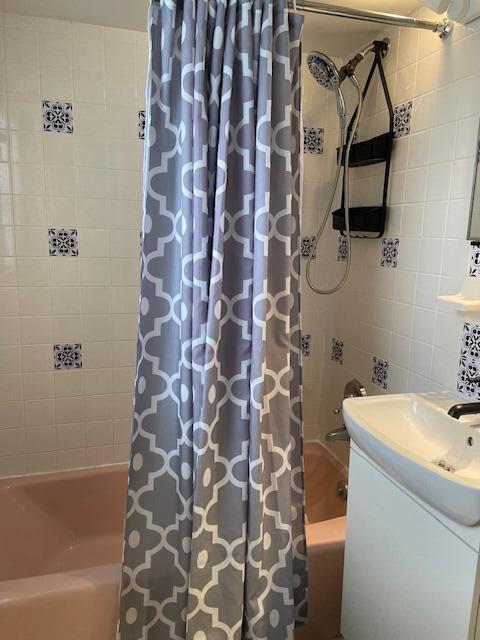 bathroom featuring tile walls and shower / bath combination with curtain