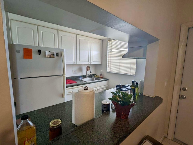 kitchen with white cabinetry, sink, white dishwasher, and refrigerator