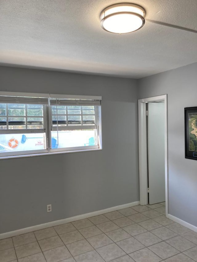 spare room with light tile patterned floors and a textured ceiling