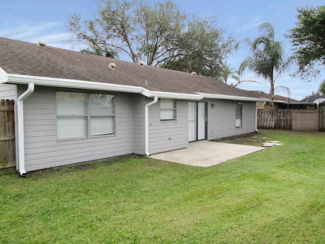 back of property with a yard and a patio area