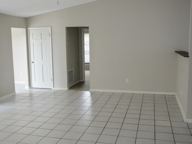 tiled empty room with vaulted ceiling