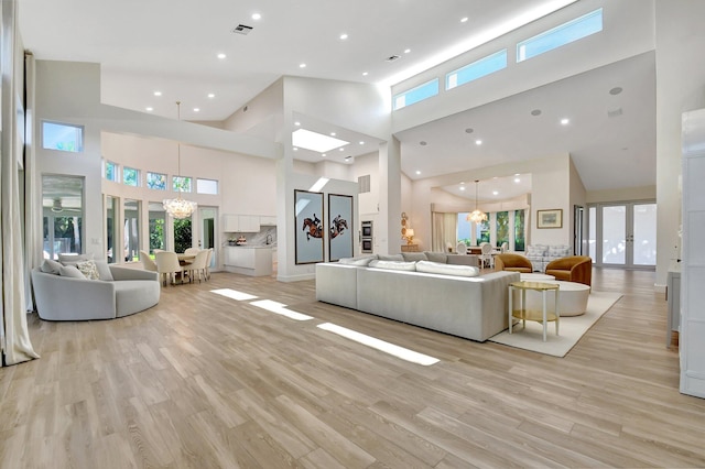 living room with plenty of natural light, a chandelier, and light wood-type flooring