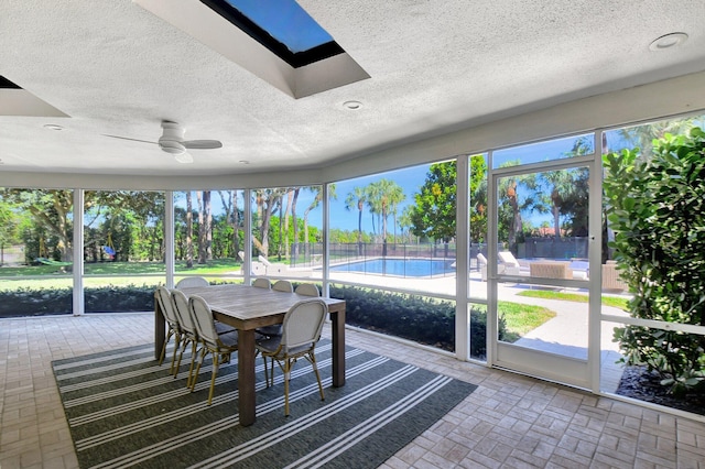 sunroom / solarium featuring ceiling fan and a skylight