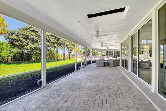 unfurnished sunroom featuring ceiling fan