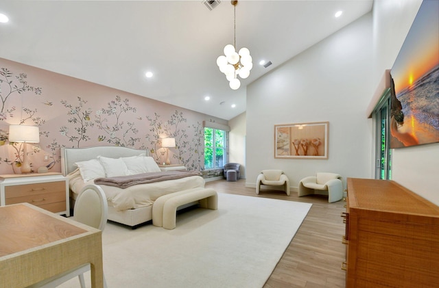 bedroom featuring high vaulted ceiling, a notable chandelier, and light hardwood / wood-style floors